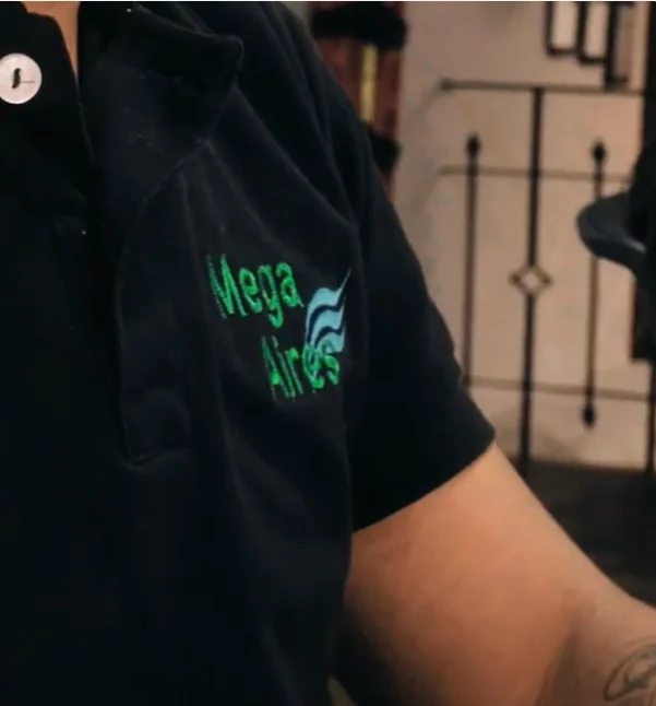 Polo negro del uniforme de Mega Aires con el logo bordado en verde y azul